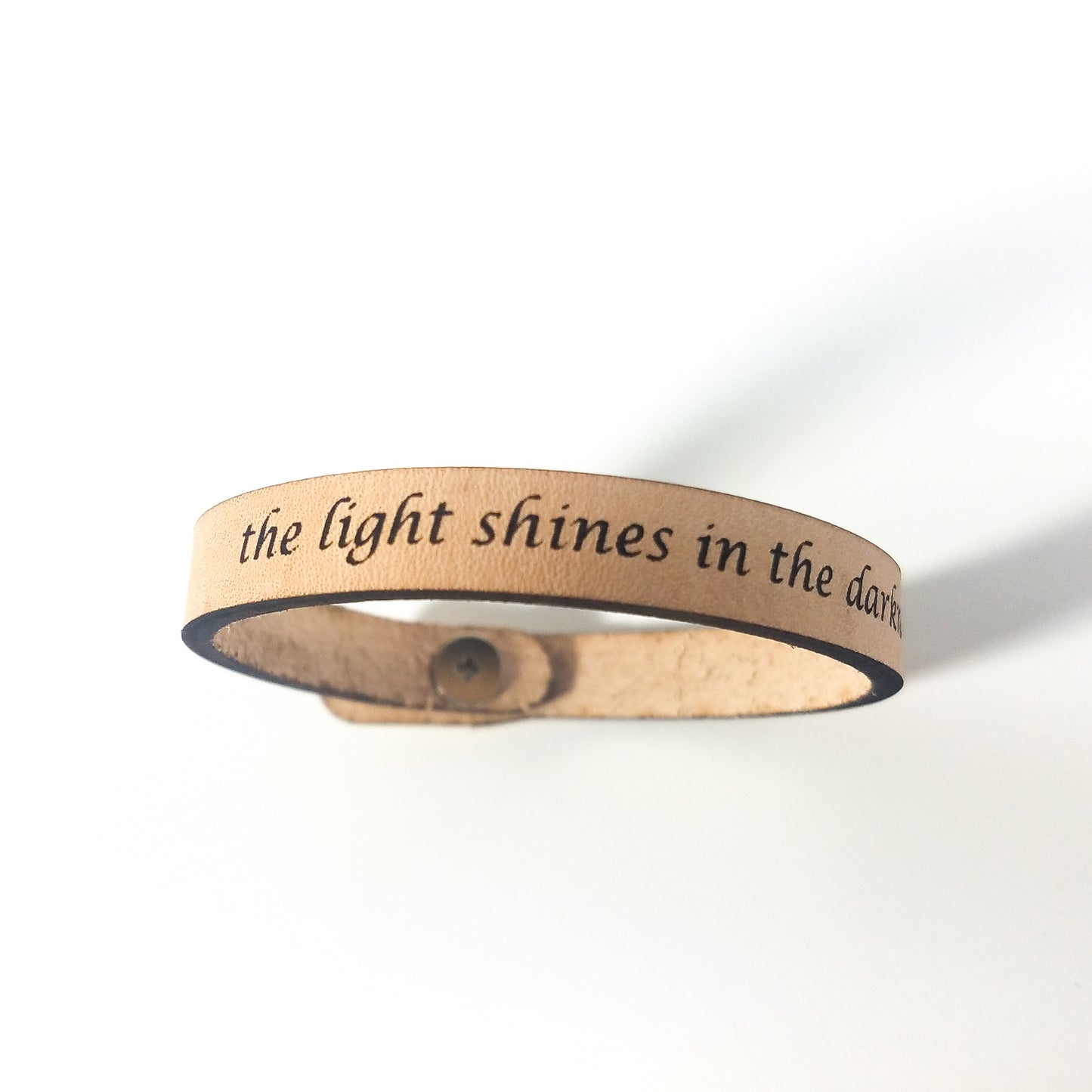 Wooden bracelet with engraved text on a white background
