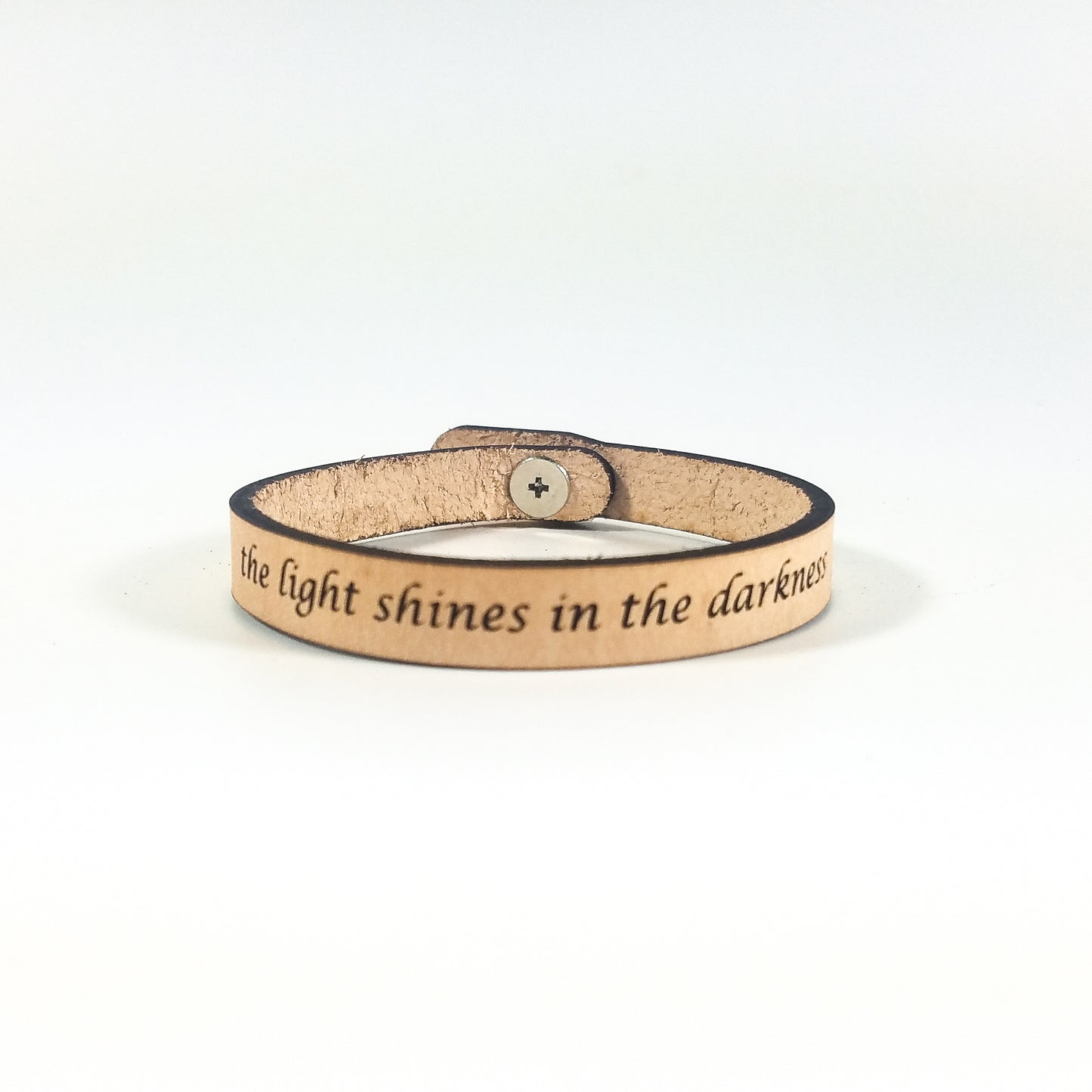 Leather bracelet with engraved text on a white background